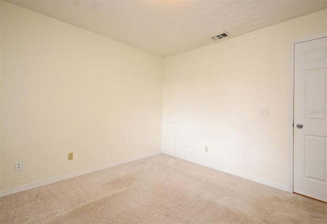 empty room with light colored carpet, visible vents, and baseboards