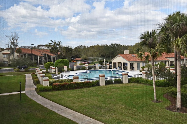 pool featuring a patio area, a lawn, and fence