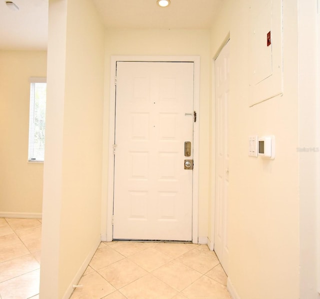 hall with light tile patterned floors, recessed lighting, baseboards, and electric panel