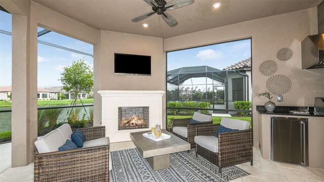 sunroom / solarium with ceiling fan, a wealth of natural light, and a tile fireplace