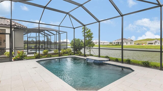 pool featuring a lanai, a patio area, and a water view