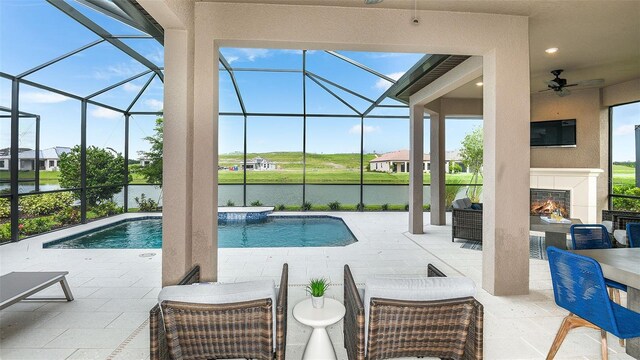 pool with glass enclosure, a patio, and ceiling fan