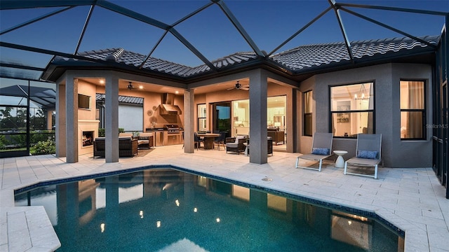 outdoor pool featuring area for grilling, grilling area, a large fireplace, ceiling fan, and a patio area