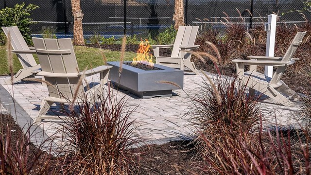 view of patio featuring an outdoor fire pit and fence