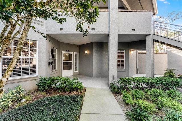 entrance to property featuring a patio area and stucco siding