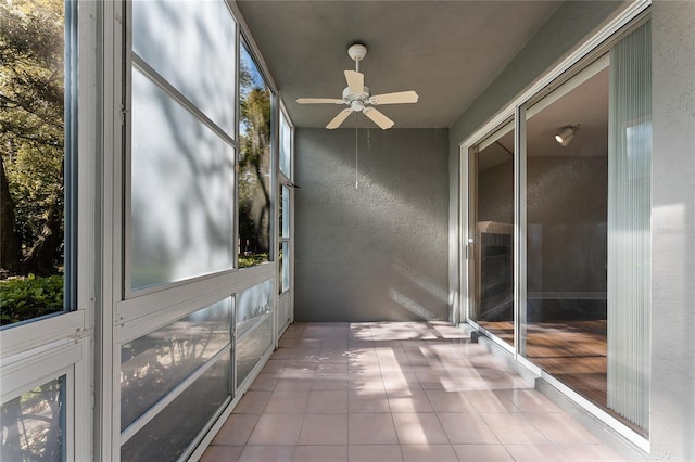 unfurnished sunroom with a ceiling fan