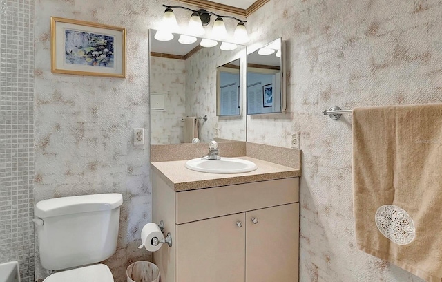 bathroom featuring toilet, ornamental molding, vanity, and wallpapered walls