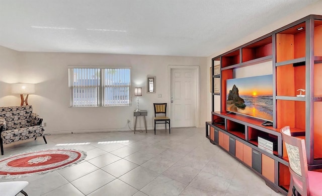 sitting room with built in features, light tile patterned floors, and a textured ceiling