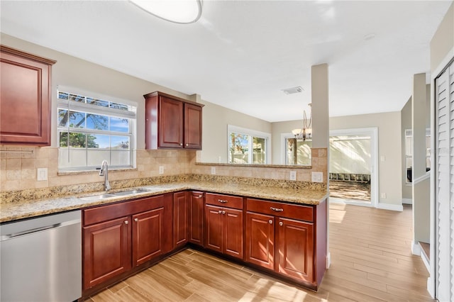 kitchen featuring visible vents, light wood-style flooring, a sink, tasteful backsplash, and dishwasher