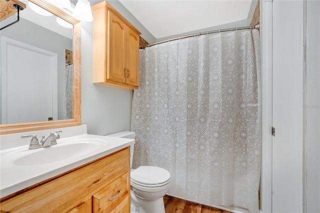 full bathroom with a shower with shower curtain, toilet, vanity, and wood finished floors