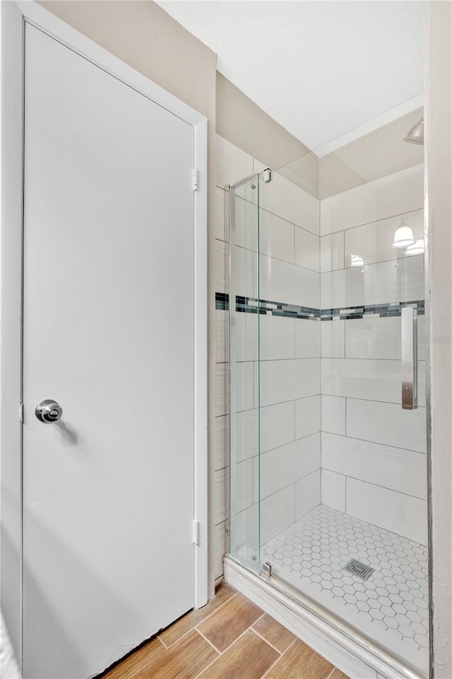 bathroom featuring a shower stall and wood finish floors