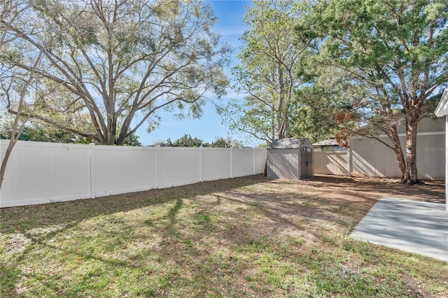 view of yard with an outbuilding, a fenced backyard, and a storage shed