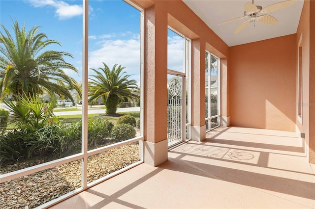 unfurnished sunroom featuring a ceiling fan