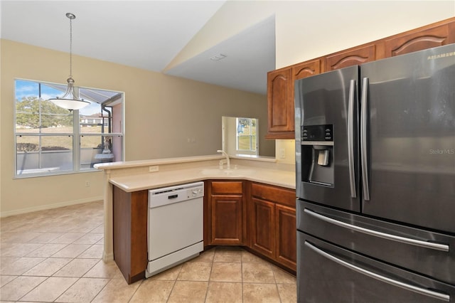 kitchen featuring a peninsula, light countertops, vaulted ceiling, dishwasher, and stainless steel fridge