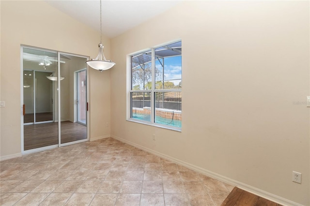 spare room with baseboards and lofted ceiling