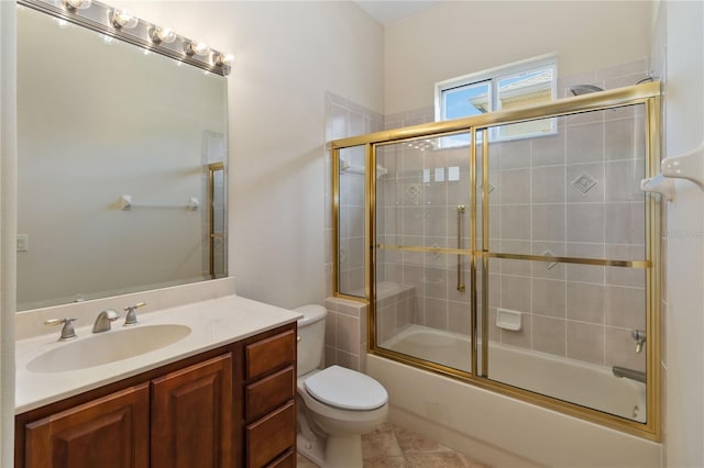 full bath with vanity, toilet, and bath / shower combo with glass door