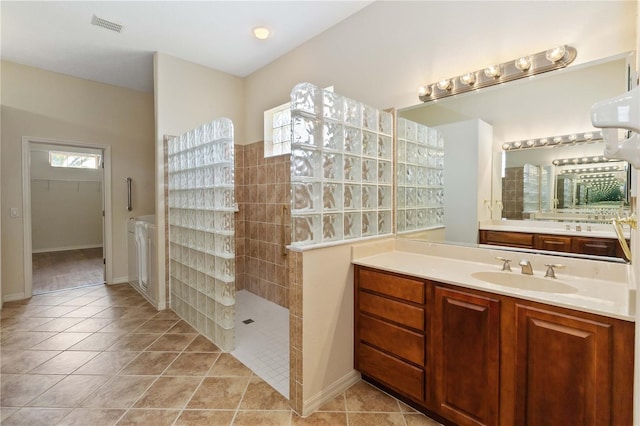 full bathroom featuring vanity, tile patterned floors, a walk in shower, and visible vents