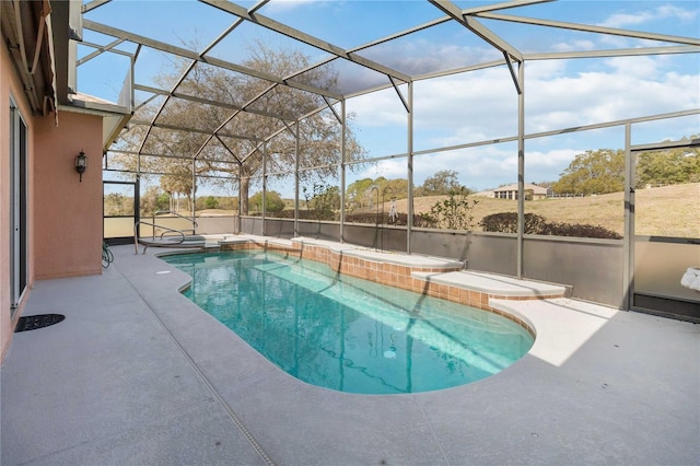 outdoor pool with glass enclosure, a jacuzzi, and a patio