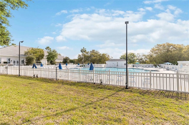 community pool with a lawn and fence