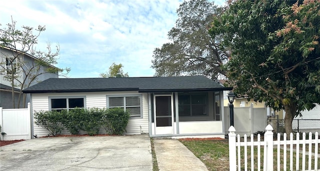 view of front of home featuring roof with shingles and fence