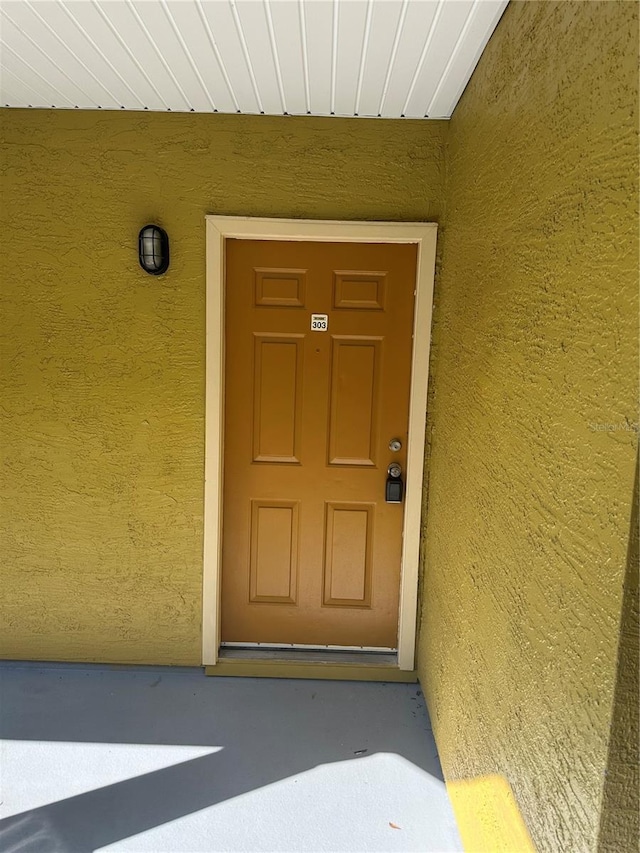 doorway to property with stucco siding