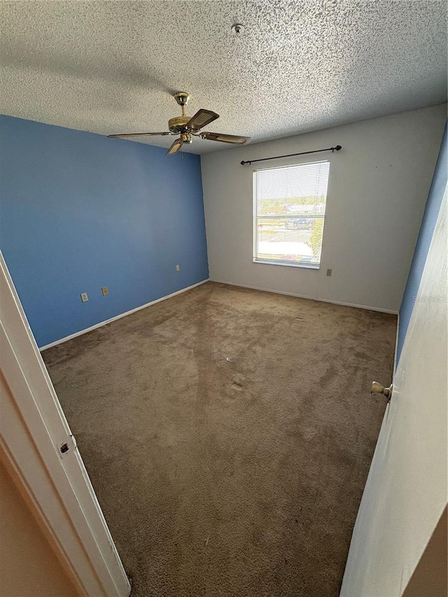 empty room featuring a textured ceiling, ceiling fan, and carpet floors