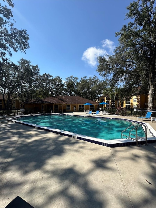 community pool featuring a patio area and fence