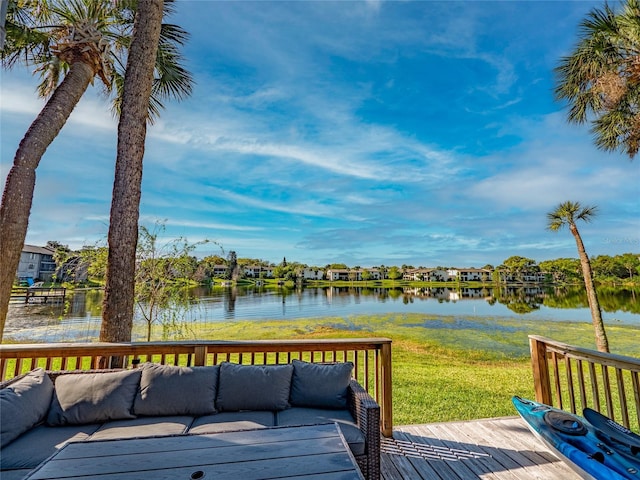 wooden terrace with a lawn and a water view