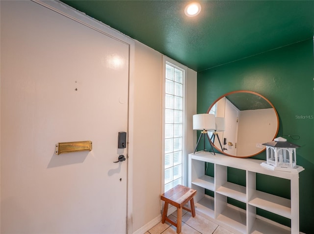 entrance foyer featuring tile patterned flooring, baseboards, and a textured ceiling