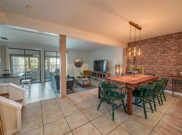 dining space featuring light tile patterned floors, visible vents, brick wall, and decorative columns