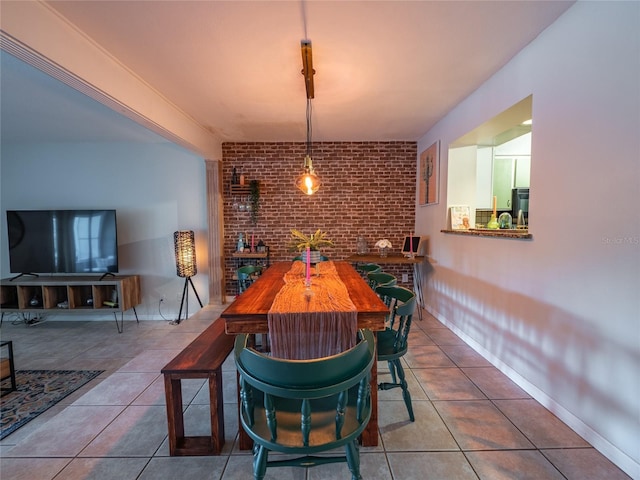 tiled dining room with brick wall and baseboards