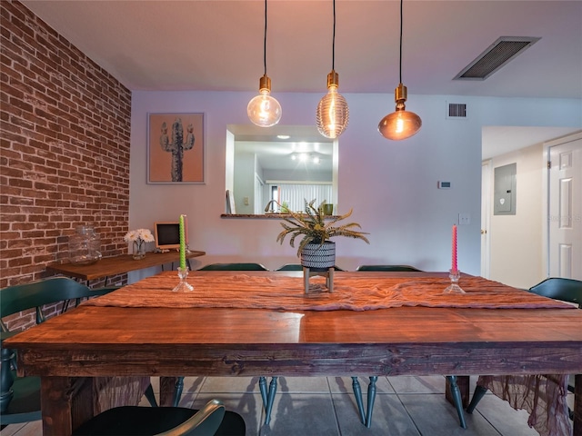 dining space with electric panel, visible vents, tile patterned floors, and brick wall