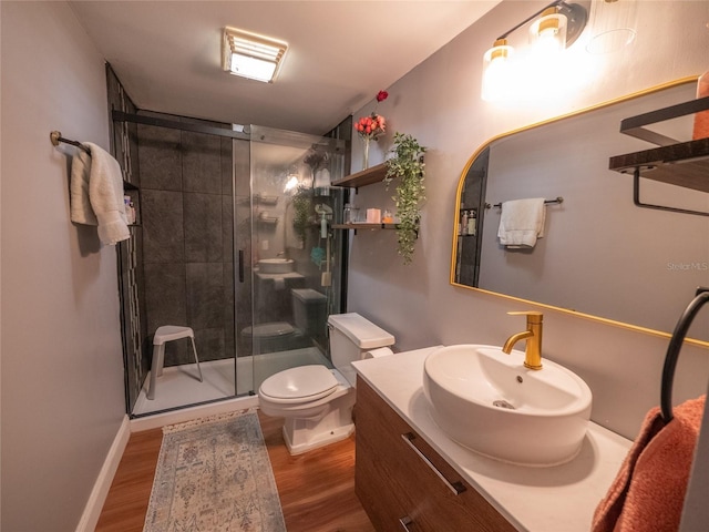 full bathroom with vanity, toilet, wood finished floors, and a stall shower