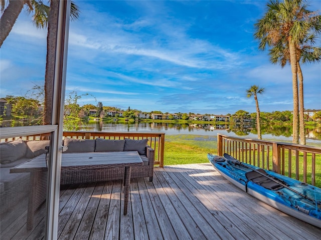 deck featuring a yard, a water view, and an outdoor hangout area