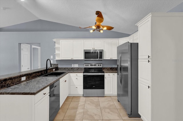 kitchen with lofted ceiling, a peninsula, a sink, ceiling fan, and stainless steel appliances