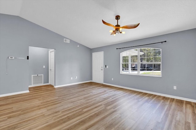 spare room featuring lofted ceiling, light wood-style flooring, a ceiling fan, and visible vents