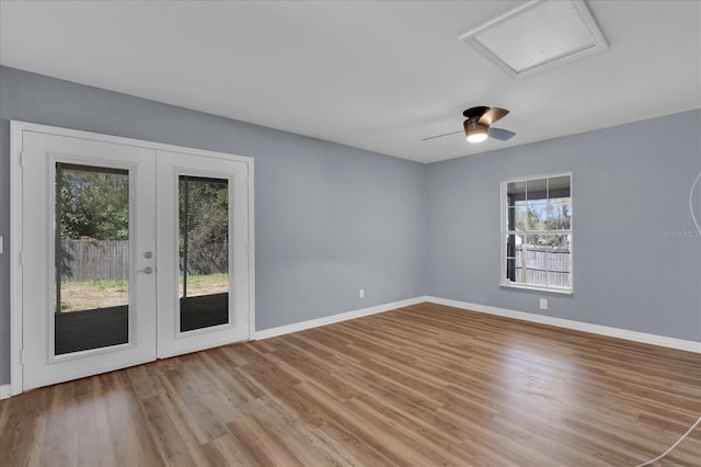 spare room with french doors, attic access, baseboards, and wood finished floors