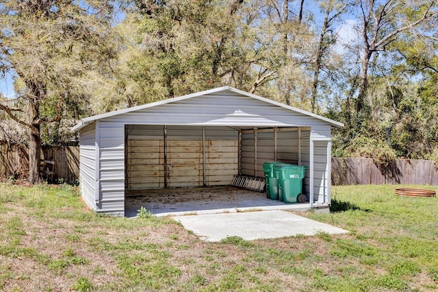 garage featuring a detached carport and fence