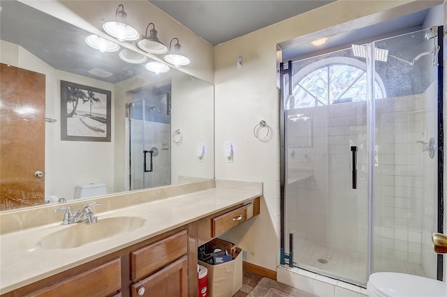 bathroom featuring vanity, toilet, and a shower stall