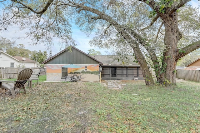 back of house featuring a lawn, a fenced backyard, and a patio area