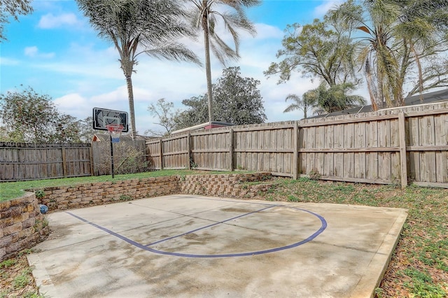 view of sport court with basketball hoop and a fenced backyard