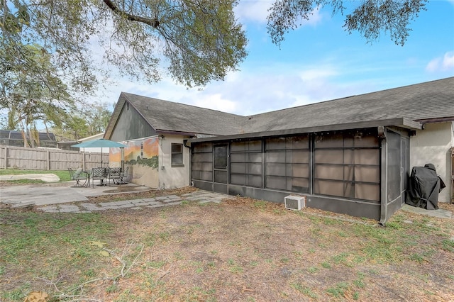 exterior space featuring a patio area, stucco siding, roof with shingles, and fence