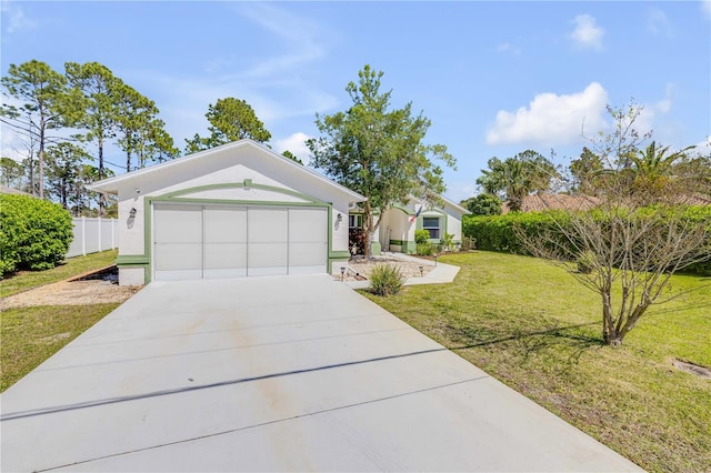 ranch-style house featuring a front yard, an attached garage, fence, and driveway