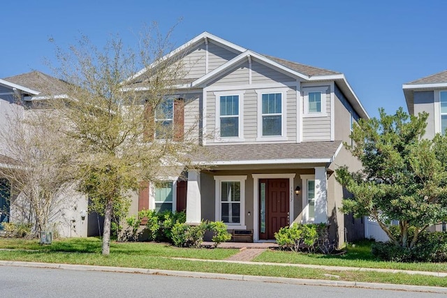 craftsman inspired home with stucco siding and a front yard