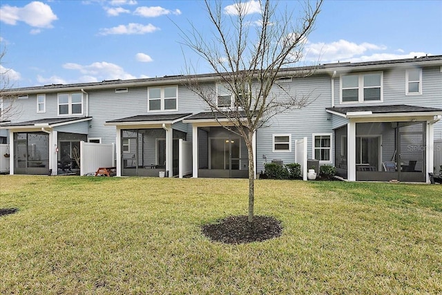 rear view of house with a lawn and a sunroom