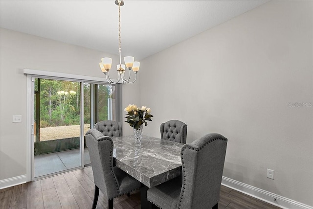 dining room with a notable chandelier, wood finished floors, and baseboards