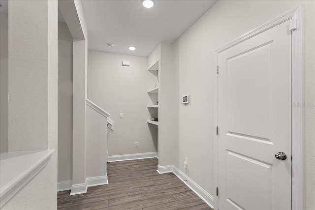 hallway featuring recessed lighting, baseboards, and wood finished floors