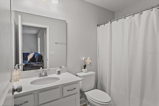 full bathroom with curtained shower, toilet, vanity, and a textured wall