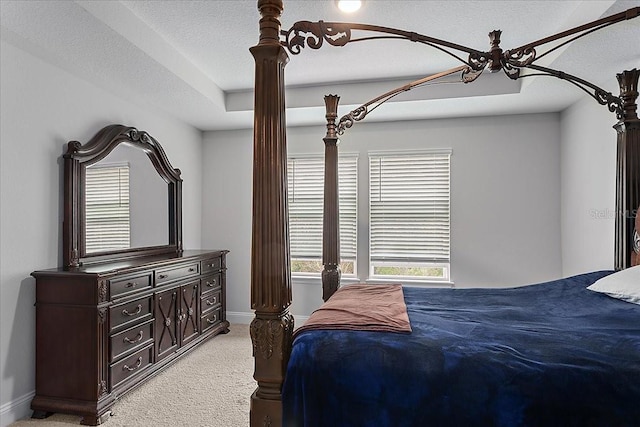 bedroom featuring a textured ceiling, baseboards, and light carpet