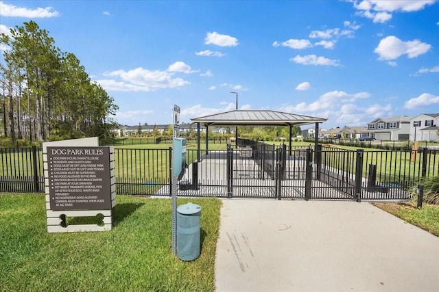 view of community featuring a lawn and fence